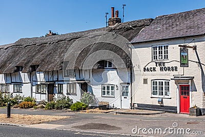 The Pack Horde pub and traditional English thatched cottages Editorial Stock Photo