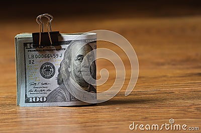 A pack of hundred-dollar bills fastened with a clerical clip. Stock Photo