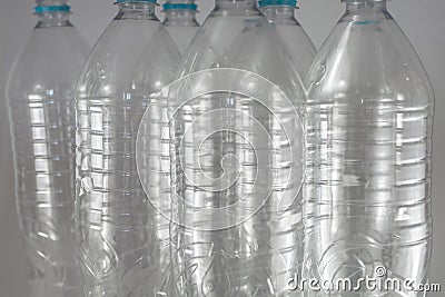 Pack of standing Bottles of a liter and a half of empty mineral water without caps just with the sealing ring on a white Stock Photo