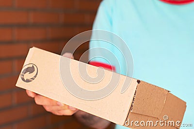 Package in a packing catron box in a man’s hand. Stock Photo