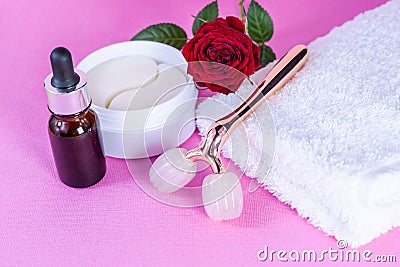 Packaging with blindfolds under the eyes. Cosmetic product. Pink Y-shaped ball roller for facial massage and eye bandages Stock Photo