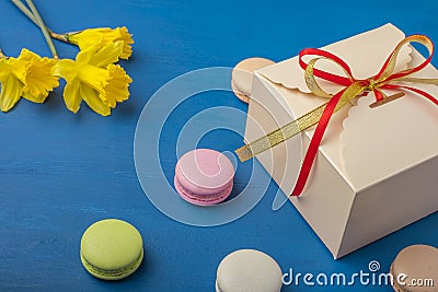 Packaging on a blue background. Colorful cookies, macarons, pastel colors. Stock Photo