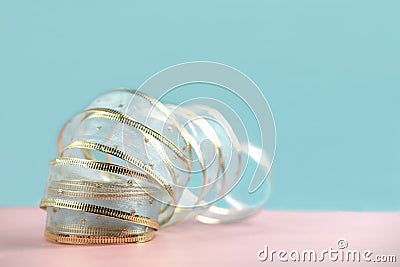 Golden ribbon for gift decor on pink and blue background. Stock Photo