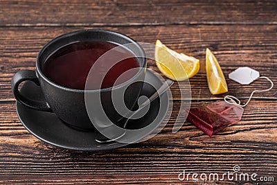 Packed brewed winter tea in black porcelain cup on wooden table Stock Photo