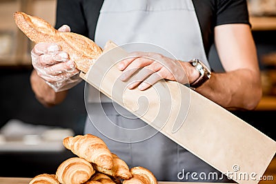 Packing bread into the paper bag Stock Photo