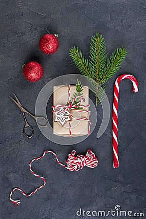 Packing Christmas gifts. Christmas gift boxes and decorations, pine branches on dark table. Present decorated with natural parts Stock Photo
