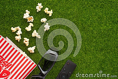 Packing with popcorn on a green lawn with 3D glasses for watching a movie. Grass Watching films about nature. In parks. Recreation Stock Photo
