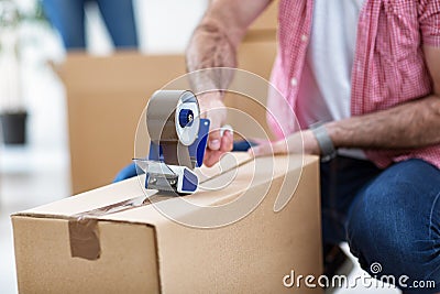 Packing things in boxes and using dust tape Stock Photo
