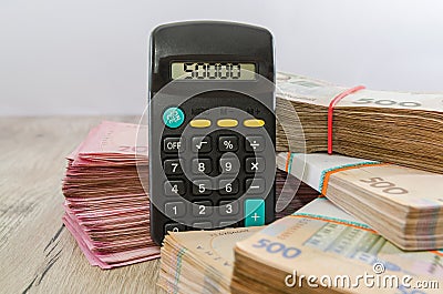 Packs of hryvnia and a calculator. Financial concept. Ukrainian banknotes. 500 and 200 hryvnias. 50,000 on the calculator display. Stock Photo