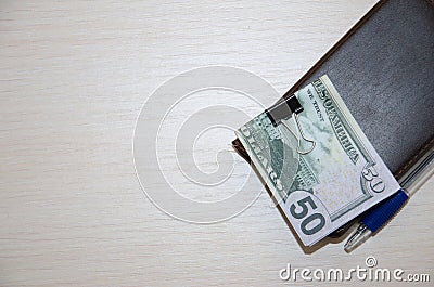 Packs of real dollar banknotes in notebook on a wooden table. Stock Photo