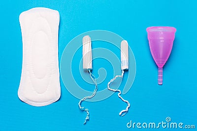 Pad, menstrual cup, tampon on a blue background. Stock Photo