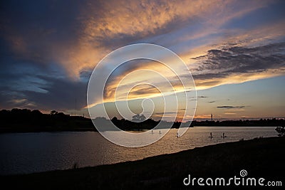 Paddle boarders on lake at sunset in West Texas Stock Photo