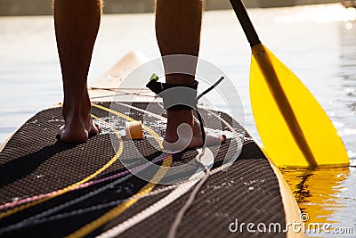 Paddleboarding on a lake, view of the legs Stock Photo