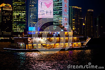 Paddlewheeler on Huangpu River and Skyscraper with advertise on the West Bank with Financal Center at night Editorial Stock Photo
