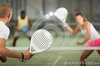 Padel racquet in hand of male player swinging to hit ball Stock Photo