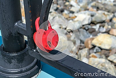 A padlock attached to the railing of the bridge as a symbol of family marriage Stock Photo