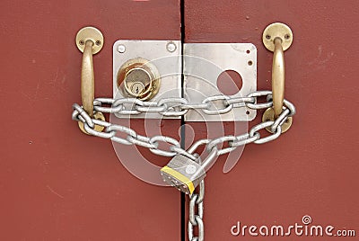 Padlock and chain linking two doors Stock Photo