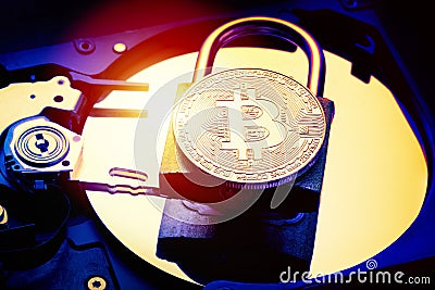 Padlock with cryptocurrency bitcoin on computer hard disk drive HDD. Internet data privacy information security concept. Electroni Stock Photo