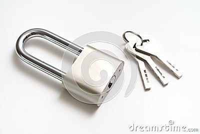 A padlock with elongated hook latch bar and three keys against a white backdrop Stock Photo