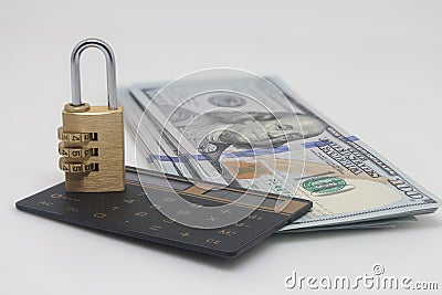 Padlock on a hundred dollar bill and a calculator on a white background, saving capital and savings. Stock Photo