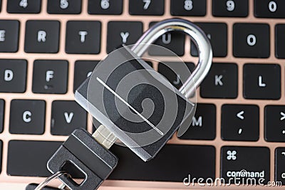 Padlock with key lying on laptop keyboard closeup Editorial Stock Photo