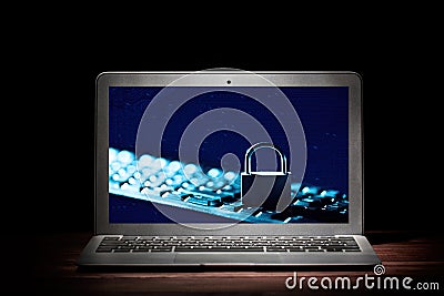 Padlock on keyboard on laptop device screen against black background. Internet data privacy information security concept Stock Photo