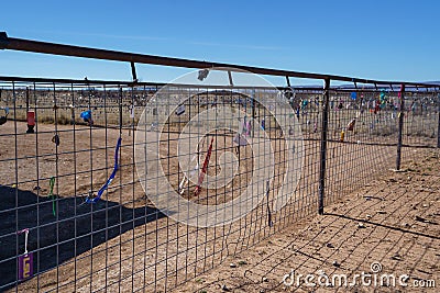 Padlocks, love locks, and keychains on a wire fence in the desert Editorial Stock Photo