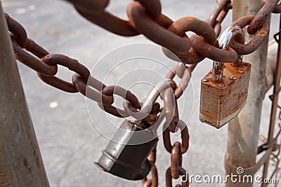 Padlocks And Rusted Chains Secure Gate At Industrial Site Stock Photo