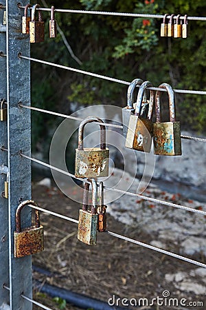 Padlocks symbolize unity and love forever. Locks hanging on fence ropes in the park Editorial Stock Photo