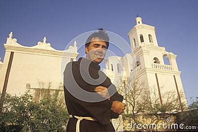 Padre stands in front of Mission San Xavier Del Bac, erected between 1783 and 1897 in Tucson Arizona Editorial Stock Photo
