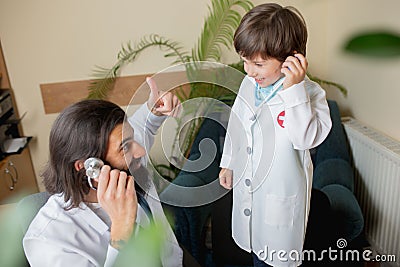 Paediatrician doctor examining a child in comfortabe medical office Stock Photo