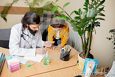 Paediatrician doctor examining a child in comfortabe medical office Stock Photo