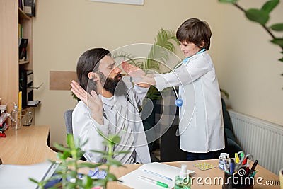 Paediatrician doctor examining a child in comfortabe medical office Stock Photo