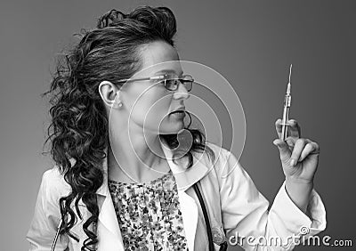 Paediatrician woman looking at syringe on Stock Photo