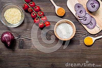 paella ingredients with rice, salt, spices and tomatoes on wooden table background top view mockup Stock Photo