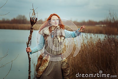 Woman is a shaman with a staff in her hands. Stock Photo