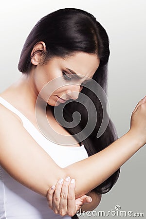 Pain in the elbow. The girl holds her hand for an elbow. Painful sensations in the area of the hand. Dislocation. Fracture. The co Stock Photo