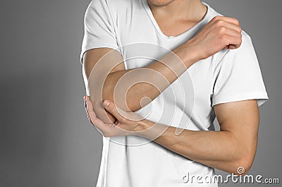 Pain in the elbow. The man holds his hand. Close up Stock Photo