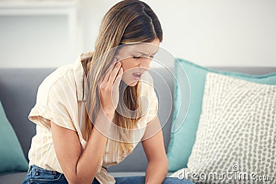 This pain is excruciating. an attractive woman experiencing a toothache. Stock Photo