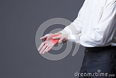 Pain in hand, joint inflammation, carpal tunnel syndrome on gray background Stock Photo