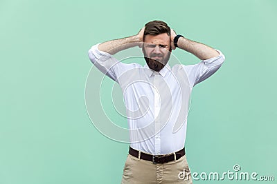 Pain in head. Pained businessman, has a headache, isolated on light green background. Stock Photo