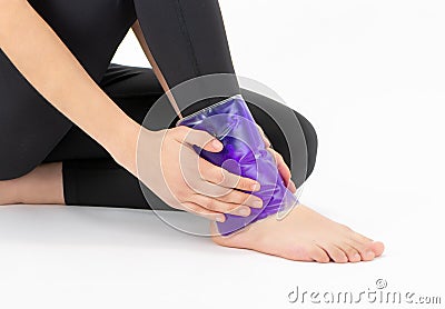 Pain relief the woman puts the gel pack to the foot Stock Photo