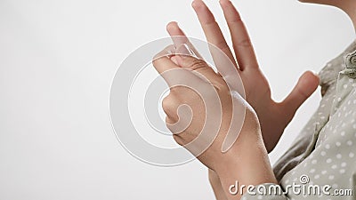 Pain and snapping fingers. Female hand tries to stretch fingers out and click her joints on white background. Close-up Stock Photo
