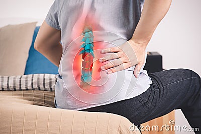 Pain in the spine, a man with backache at home, injury in the lower back Stock Photo