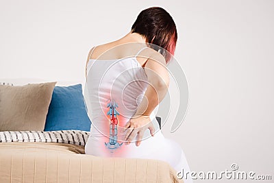 Pain in the spine, woman with backache at home, injury in the lower back Stock Photo