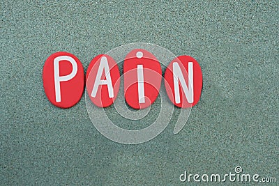 Pain word composed with red colored stone letters over green sand Stock Photo