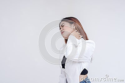 A pained young woman with tilted head holding her stiffed neck in pain. Isolated on a white background Stock Photo