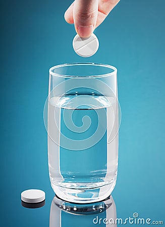 Painkiller tablet in glass of water with bubbles Stock Photo