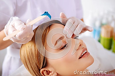 Constant client of beauty salon enjoying painless depilation Stock Photo