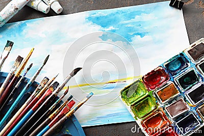 Paint brushes with watercolors and beautiful picture on table Stock Photo